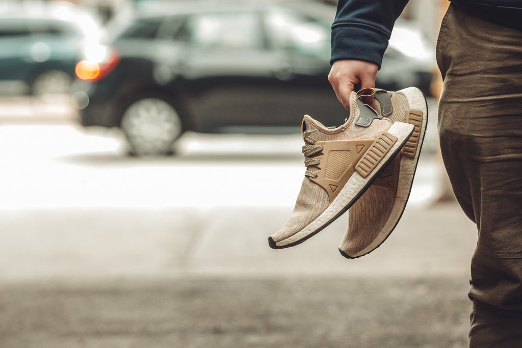 Person holding a pair of clean, polished shoes as an example of our shoe cleaning service